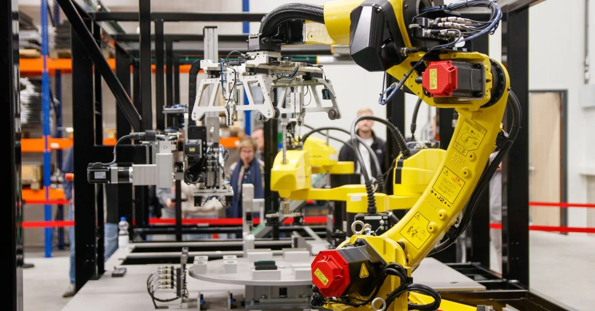Gros plan d'un bras robotique industriel jaune en action dans une usine de fabrication moderne.