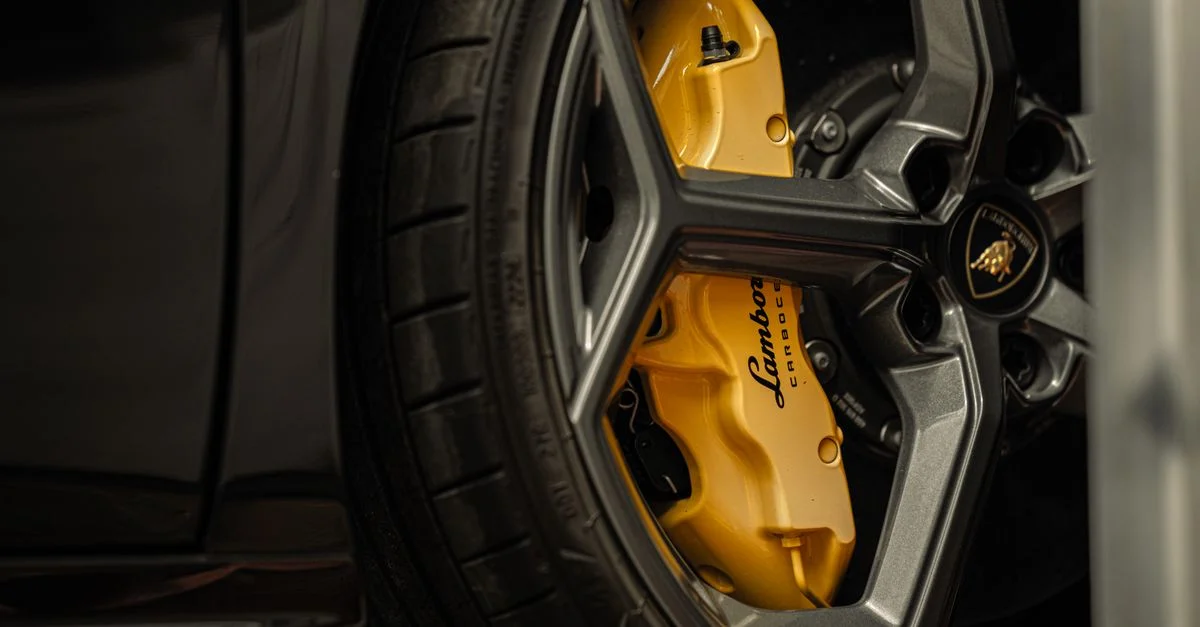 Vue détaillée d'une roue de voiture de luxe avec un étrier de frein jaune distinctif, illustrant le design automobile.