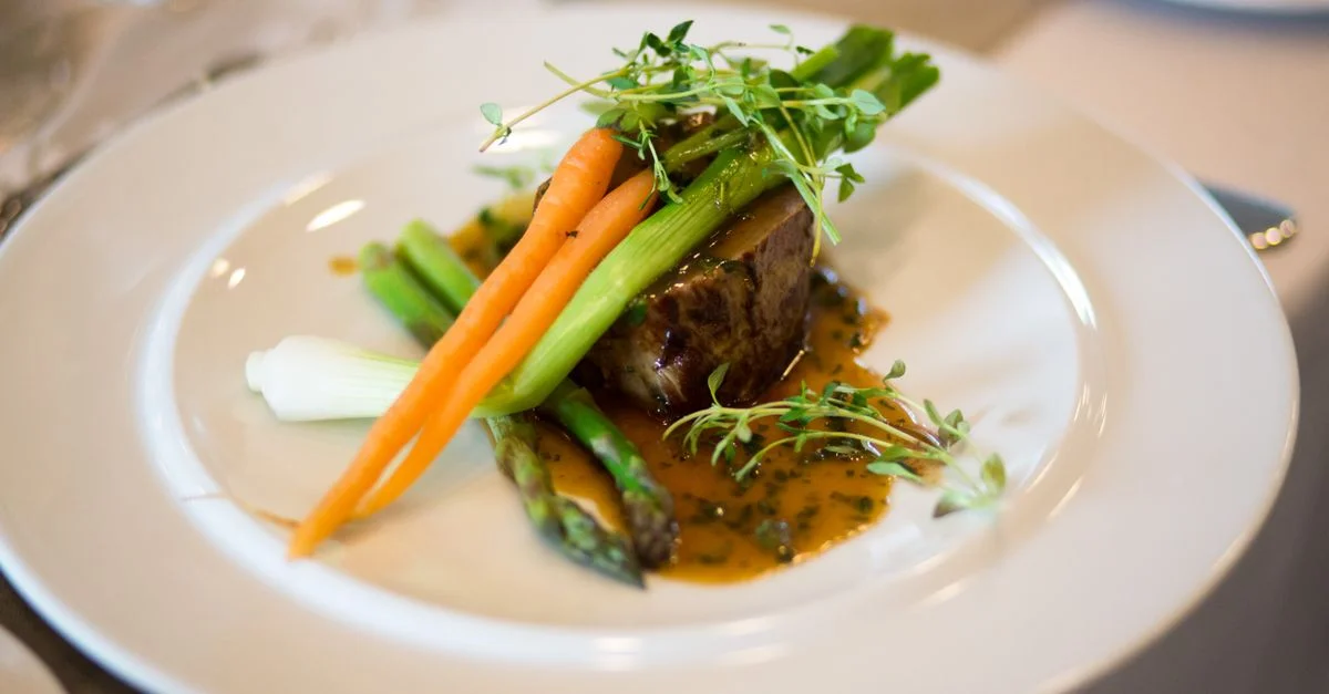 Repas gastronomique luxueux élégamment présenté avec des légumes et une sauce.